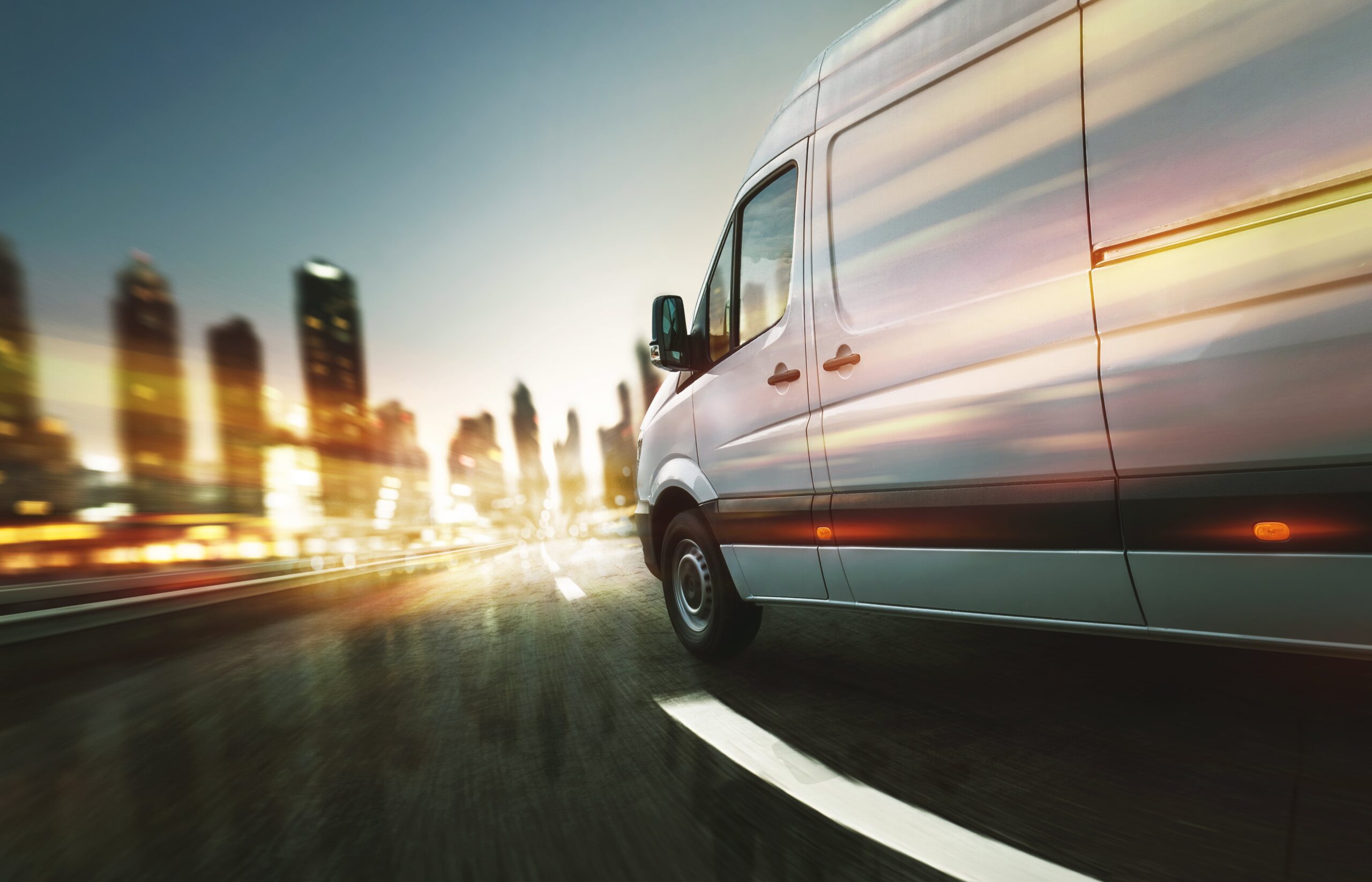 Van driving towards city with blurred lighting.