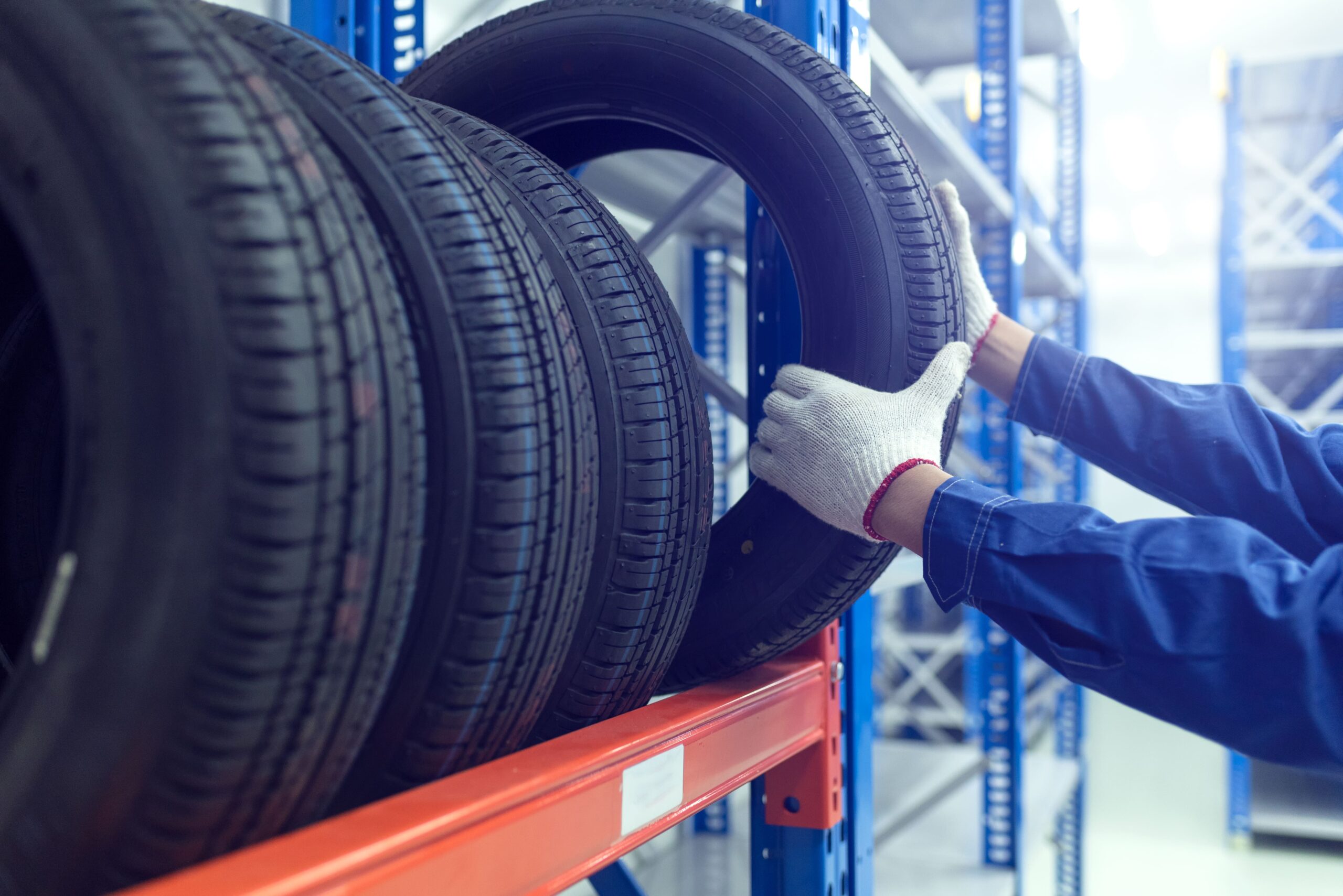 Focused shot of technician selecting tyre from tyre rack