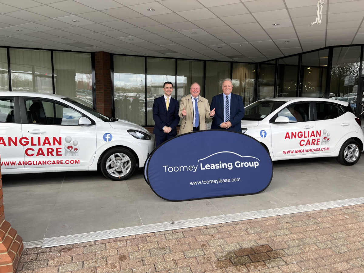3 Businessmen next to new cars