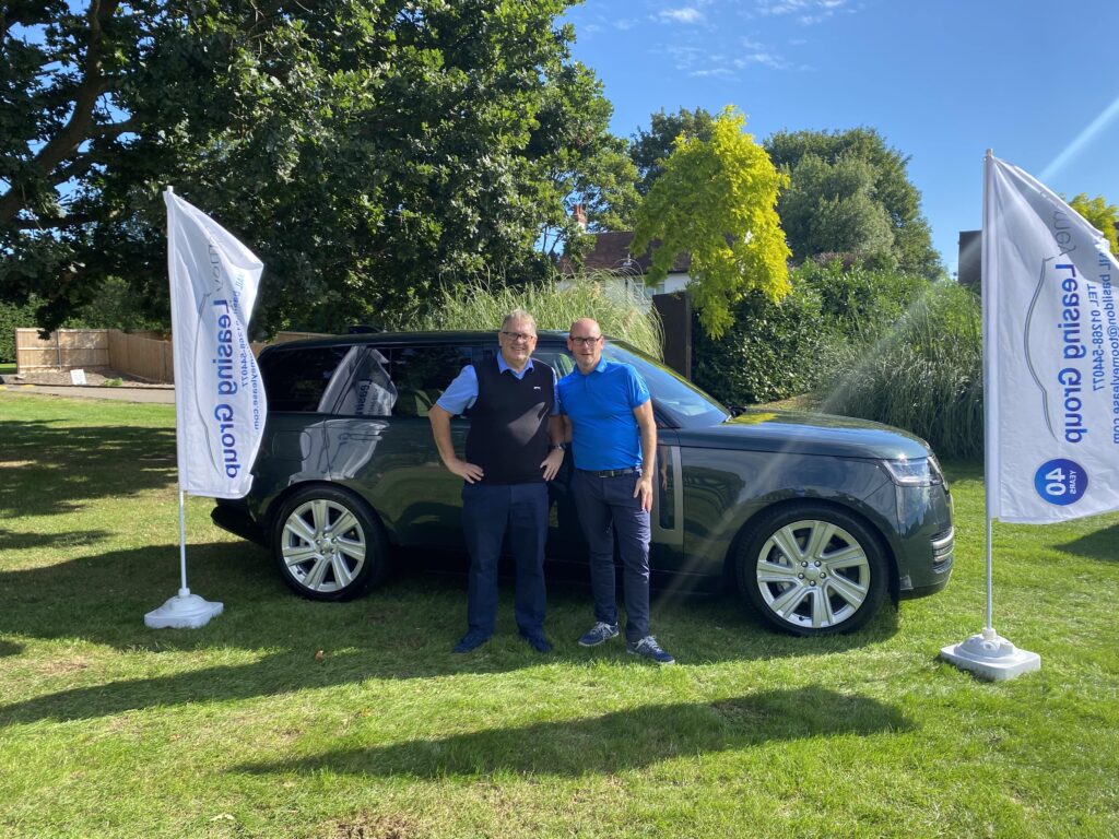 Members of the Toomey Leasing Group team standing in front of Range Rover on the Golf field