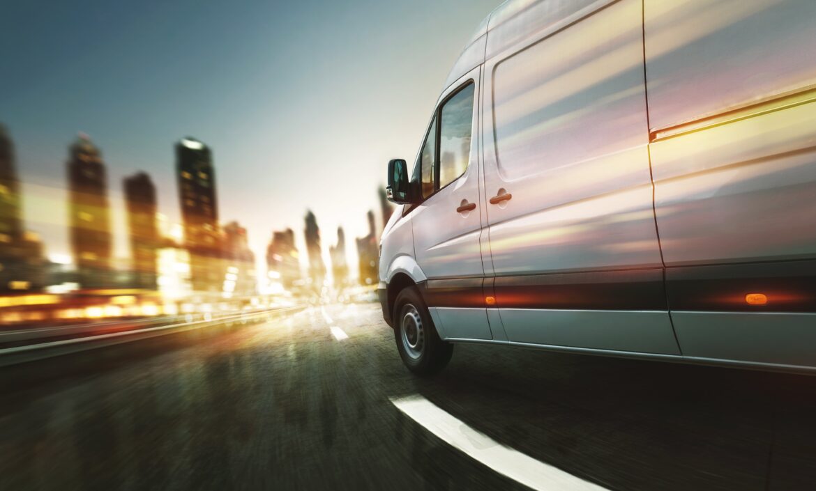 Van driving towards city with blurred lighting.