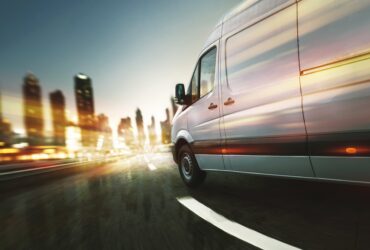 Van driving towards city with blurred lighting.