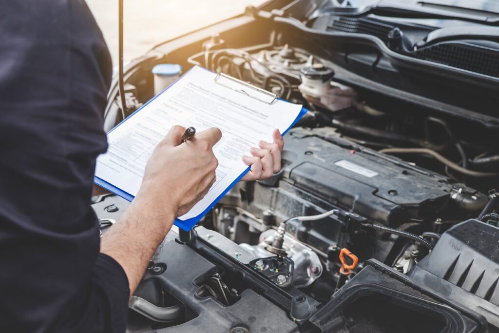 Mechanic holding clipboard whilst conducting an engine check