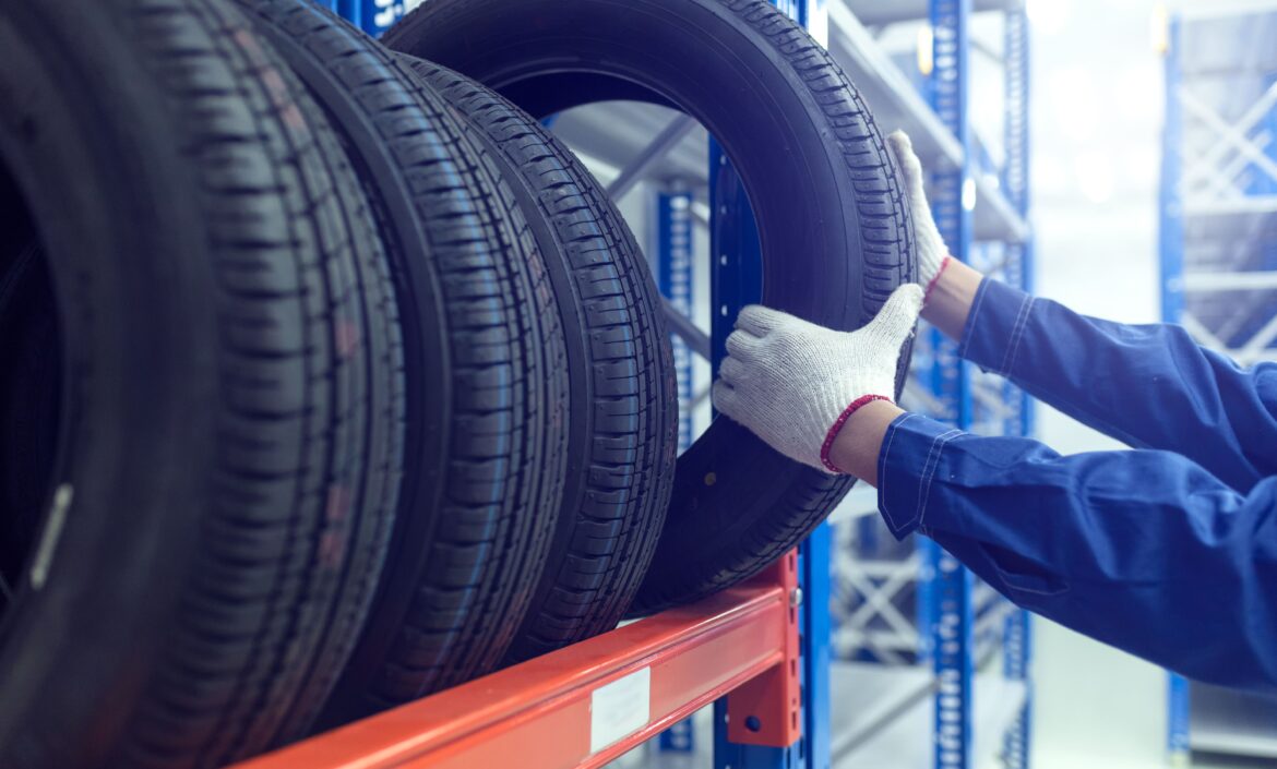 Focused shot of technician selecting tyre from tyre rack