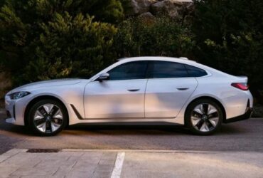 BMW i4 side profile in a suburban area
