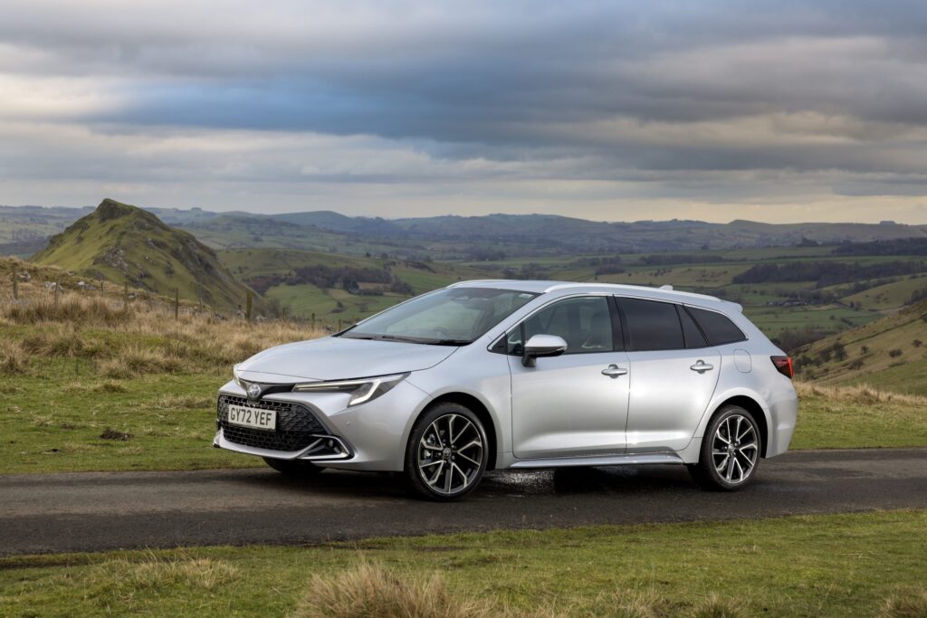 Toyota Corolla driving in a scenic mountain range